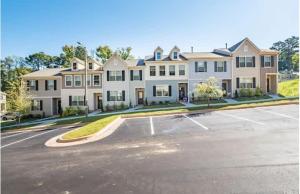an empty parking lot in front of a large house at Upscale King 3BR Townhouse Mins to Cary & NC State in Raleigh