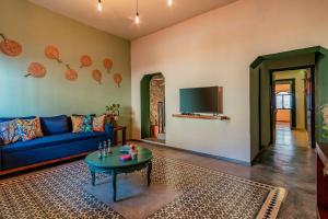 a living room with a blue couch and a tv at Ya ax nah Luxury house in downtown Mérida in Mérida
