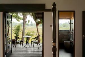a door leading to a patio with a table and chairs at Kirindi Paddy Isle - Boutique Villa in Negombo