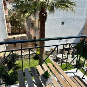 a balcony with a palm tree and a bench at R&T Apartments in Kallithea Halkidikis
