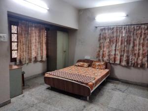 a bedroom with a bed in a room with curtains at Metropolitan Retreat in Bengaluru