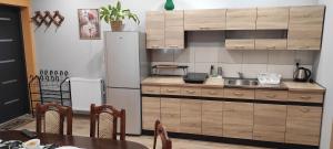 a kitchen with a refrigerator and a table in a room at Pensjonat Jak w Domu in Ostróda