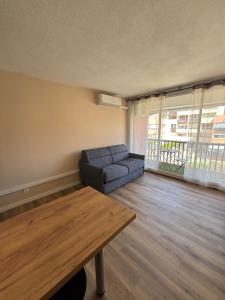 a living room with a couch and a table at Studio Le saint Clair centre port in Cap d'Agde