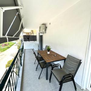 a patio with a wooden table and chairs at R&T Apartments in Kallithea Halkidikis