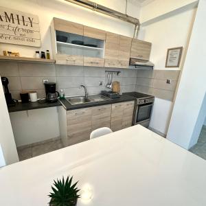 a kitchen with a white table and a sink at R&T Apartments in Kallithea Halkidikis