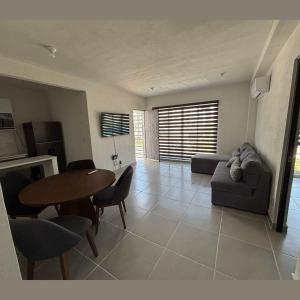 ein Wohnzimmer mit Tisch und Couch in der Unterkunft Comodo departamento en Barra Vieja Acapulco in Acapulco
