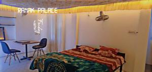 Un dormitorio con una cama y una mesa y sillas. en Ranak Palace - A Luxury Home Stay, en Jaipur