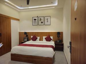 a bedroom with a large bed with red pillows at The Royal Orchid in Alīgarh +24 photos