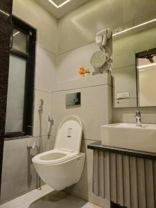 a bathroom with a toilet and a sink at The Royal Orchid in Alīgarh