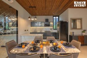 a kitchen and dining room with a table and chairs at StayVista at Palm Tree Breeze with Pool, BBQ, Bonfire in Jaipur