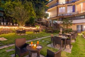 a restaurant with tables and chairs in a yard at night at Karnika Resort Levelup Boutique-Dharamshala in Dharmsala