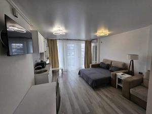 ein Wohnzimmer mit einem Bett und einer Couch in der Unterkunft COZY studiou Mamaia Nord by Alezzi in Mamaia Nord – Năvodari