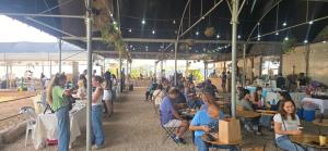 a group of people sitting at tables in a restaurant at בית בכפר in Kefar Pines