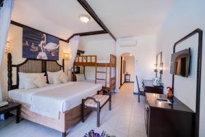 a bedroom with a bed and a desk and a television at PrideInn Flamingo Beach Resort & Spa Mombasa in Mombasa +216 photos
