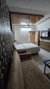 艾哈迈达巴德Hotel Anand Place的一间带床、沙发和电视的卧室