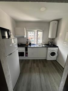 Precioso piso en Mieres con Jardín في مييريس: مطبخ مع ثلاجة بيضاء وغسالة صحون