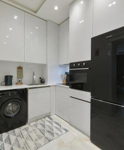 a kitchen with white cabinets and a black dishwasher at Melissa Park Baku in Baku