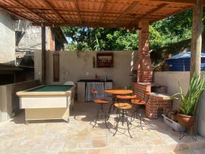 a patio with a pool table and some stools at Recanto Praia do Anil in Angra dos Reis