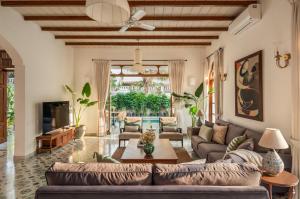 a living room with a couch and a table at Villa Fado - 4BHK Luxury Villa with Big Private Pool, Kitchen, Balcony, Patio, Caretaker, Power Backup, Security & WiFi located closer to Vagator Beach in Assagao