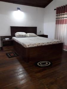a bed in a bedroom with a wooden floor at Oya hideout in Anuradhapura