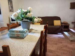a living room with a table with a vase of flowers at Charming Mountain Retreat in Pacentro, Italy in Pacentro +8 photos