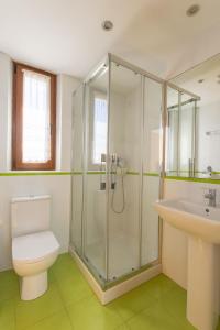 a bathroom with a shower and a toilet and a sink at La Pergola in Santillana del Mar +16 photos
