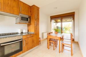 a kitchen with a table with chairs and a microwave at La Pergola in Santillana del Mar
