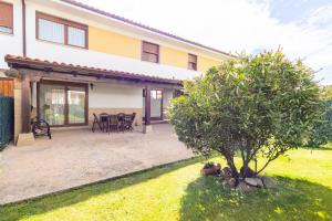 a house with a patio and a tree in the yard at La Pergola in Santillana del Mar