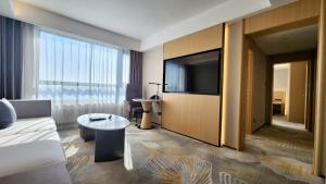 a living room with a couch and a large television at Yanshan Hotel in Beijing +8 photos