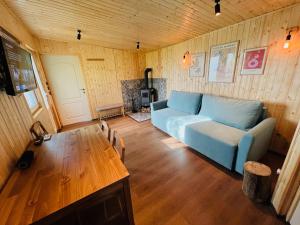 un soggiorno con un divano blu e un tavolo di Tinyhouse Snagov Lake a Ciofliceni