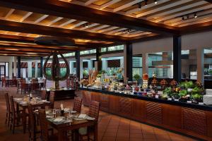 um restaurante com mesas, cadeiras e um bar em Cinnamon Lodge Habarana em Sigiriya