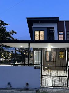 a house with a white fence in front of it at Homefortzone near D' outlet lima in Sampong
