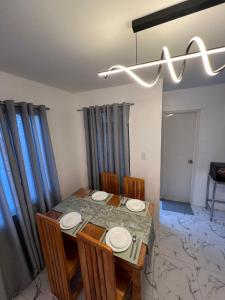 a dining room with a table and chairs and a chandelier at Homefortzone near D' outlet lima in Sampong