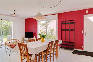 a dining room with a white table and a red wall at L'escapade de Sauvagnac in Libourne +18 photos
