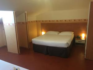 ein Schlafzimmer mit einem großen Bett mit einer weißen Tagesdecke in der Unterkunft Hotel Liberty in Sanremo