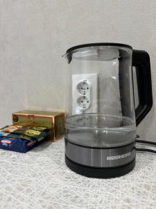 eine Küchenmaschine, die auf einer Theke neben einer Kiste steht in der Unterkunft Уютные 1комнатные апартаменты на Казииту in Oral