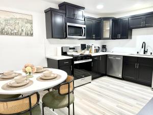 Una cocina con gabinetes negros y una mesa y sillas. en GilmoreOne, en Van Nuys