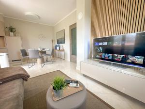 a living room with a large flat screen tv at Apartment Baska mit Poolarea - Krk, Kroatien in Baška