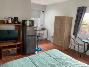 a living room with a refrigerator and a television at Seasalt 1 Cozy Studio with Full kitchen and fast WiFi in Thong Sala +9 photos