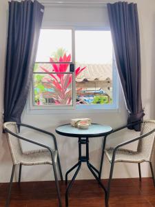a table and two chairs in front of a window at Seasalt 1 Cozy Studio with Full kitchen and fast WiFi in Thong Sala