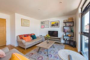 a living room with a couch and a table at Bun Penny Apartment by Keepers Cottages in Herne Bay