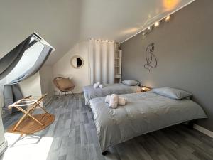 a bedroom with two beds and a table and a chair at Maison de vacances avec terrasse - 6 personnes in Montagny-lès-Beaune +18 photos