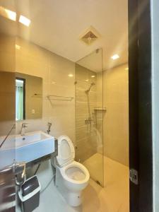 a bathroom with a toilet and a sink and a shower at MACTAN NEWTOWN FAMILY ROOM Deluxe with free wi-fi, POOL & GYM in Lapu Lapu City