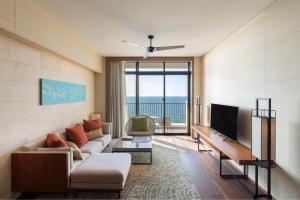 a living room with a couch and a television at Hyatt Regency Seragaki Island Okinawa in Onna +37 photos