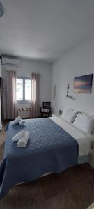 a bedroom with a large bed with towels on it at Kalliopis Rooms in Katapola