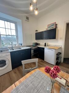 a kitchen with a washer and dryer and a table at TheFlatInJed in Jedburgh
