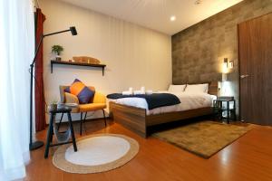 a bedroom with a bed and a chair at 御京ホテル in Tokyo