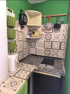 a small kitchen with a counter top with tiles at Beachfront Studio with Private Kitchen and Bath in Algeciras