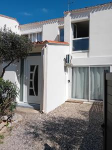 a white house with a door and a yard at studio meublé wifi à proximité du tram in Castelnau-le-Lez
