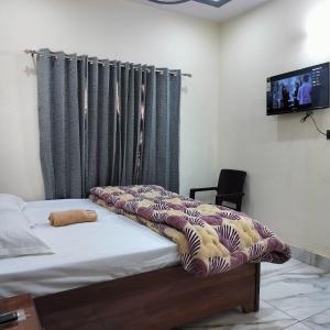 a bedroom with a bed with a blanket on it at Hotel Grand View in Barkot